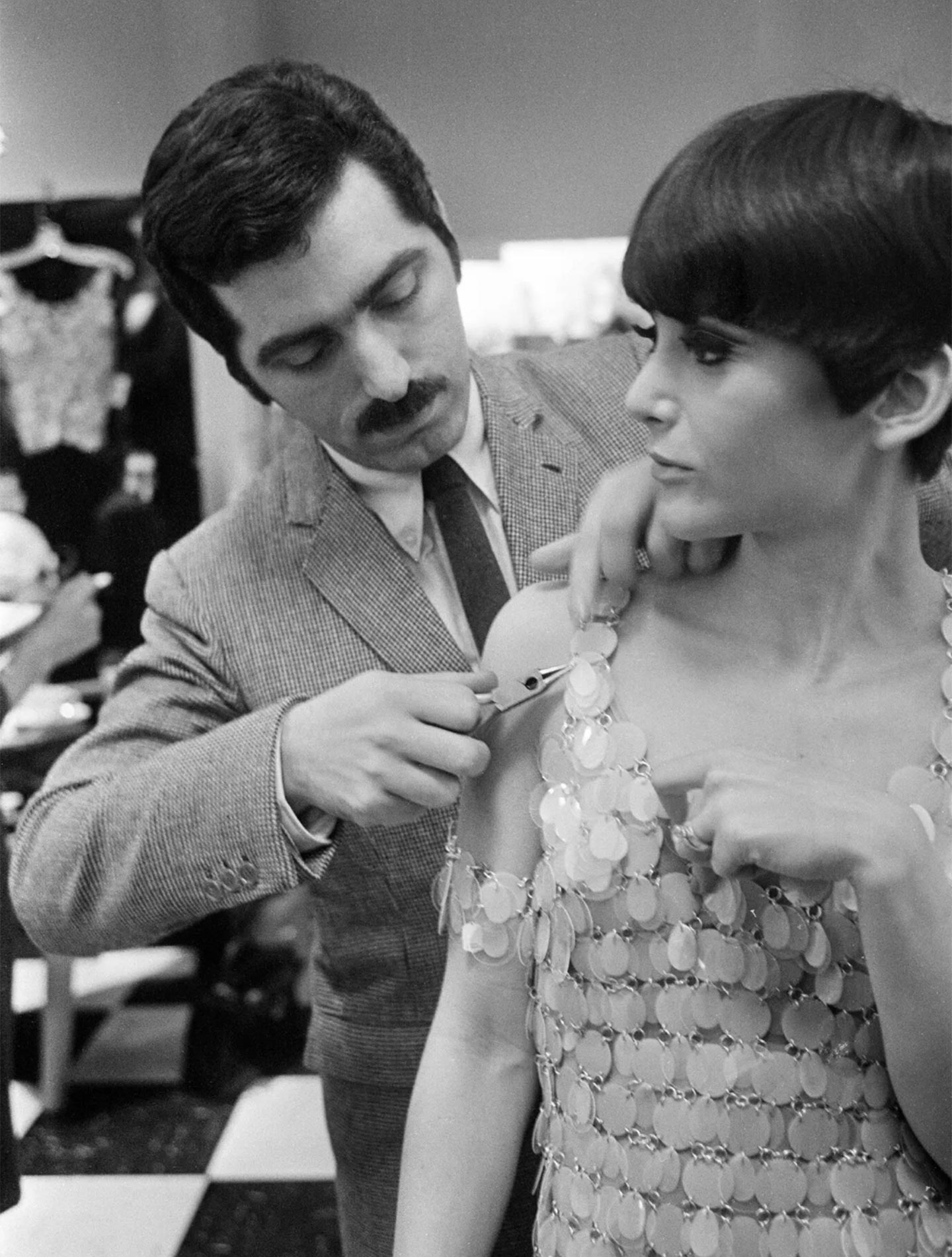 Paco Rabanne in New York in 1966, using pliers to make a repair to one of his plastic and metal dresses