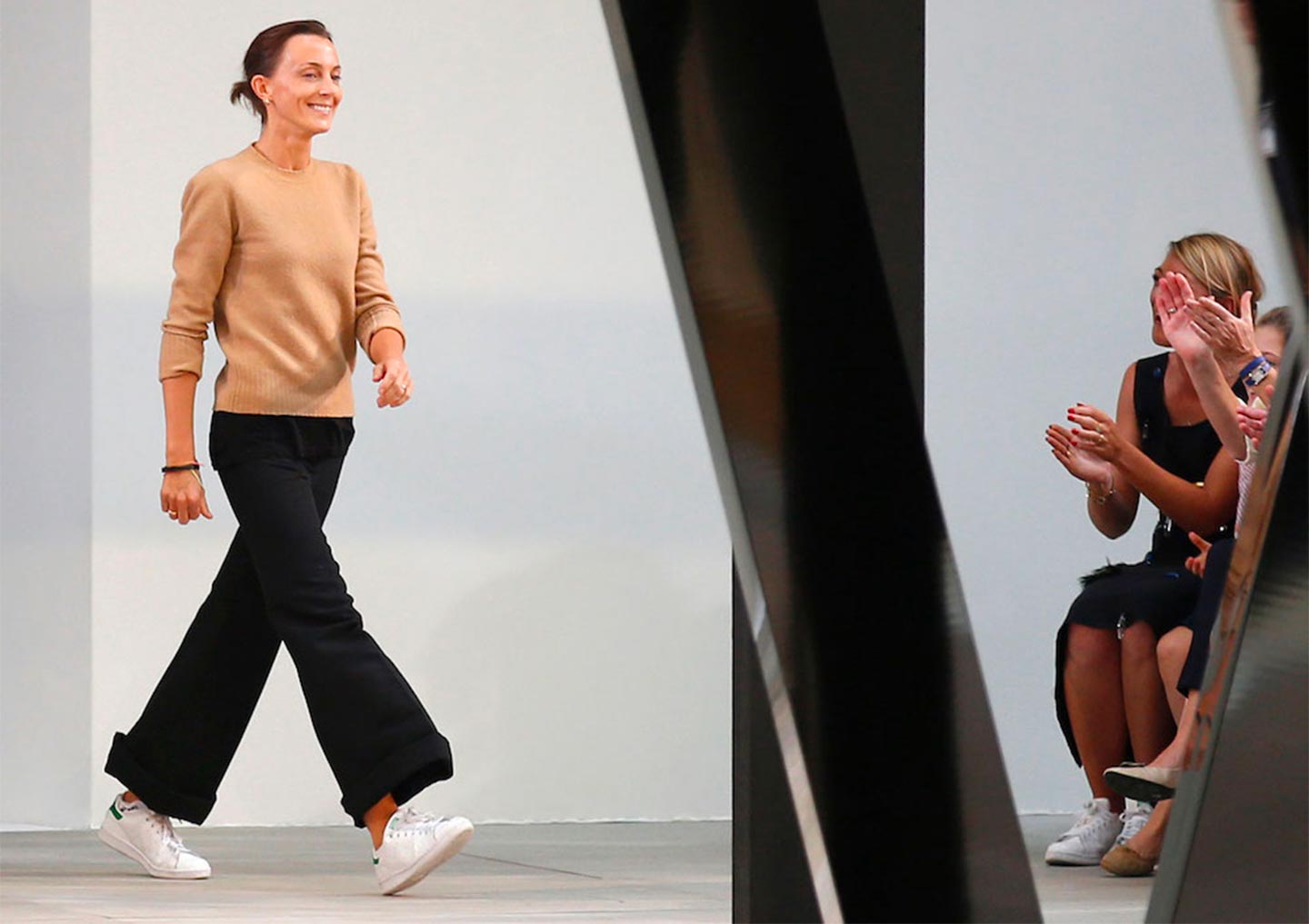 Phoebe Philo waves to the public at the end of a Céline's ready-to-wear fashion show