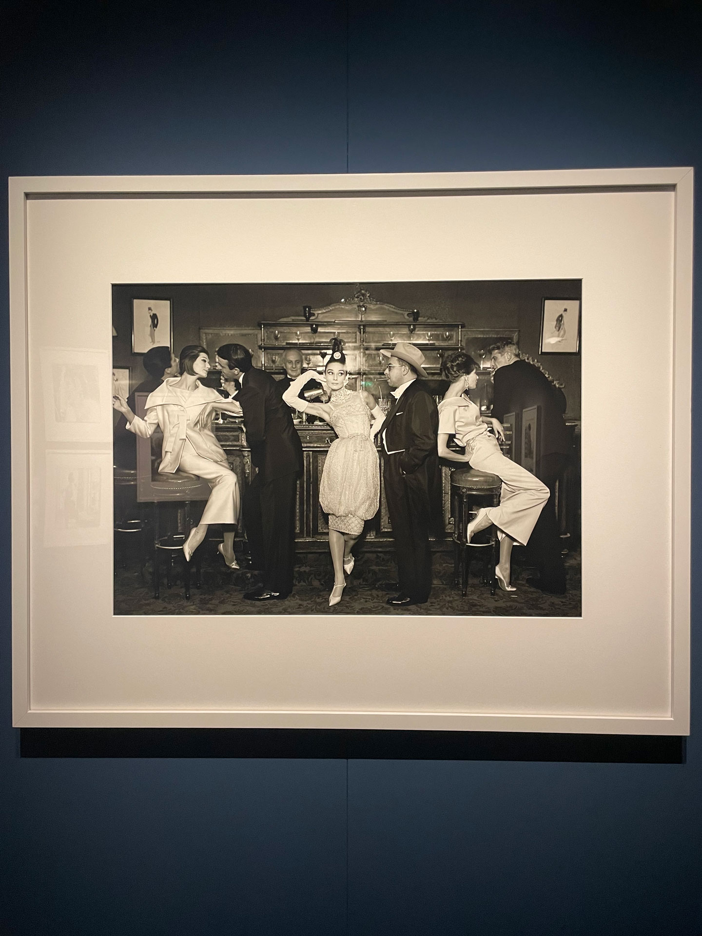 Richard Avedon, "Audrey Hepburn and Art Buchwald with Simone, Barbara Mullen, Frederick Eberstadt, and Dr. Reginald Kernan, Evening dresses by Balmain, Dior, Patou, Maxim's, Paris," August 1959