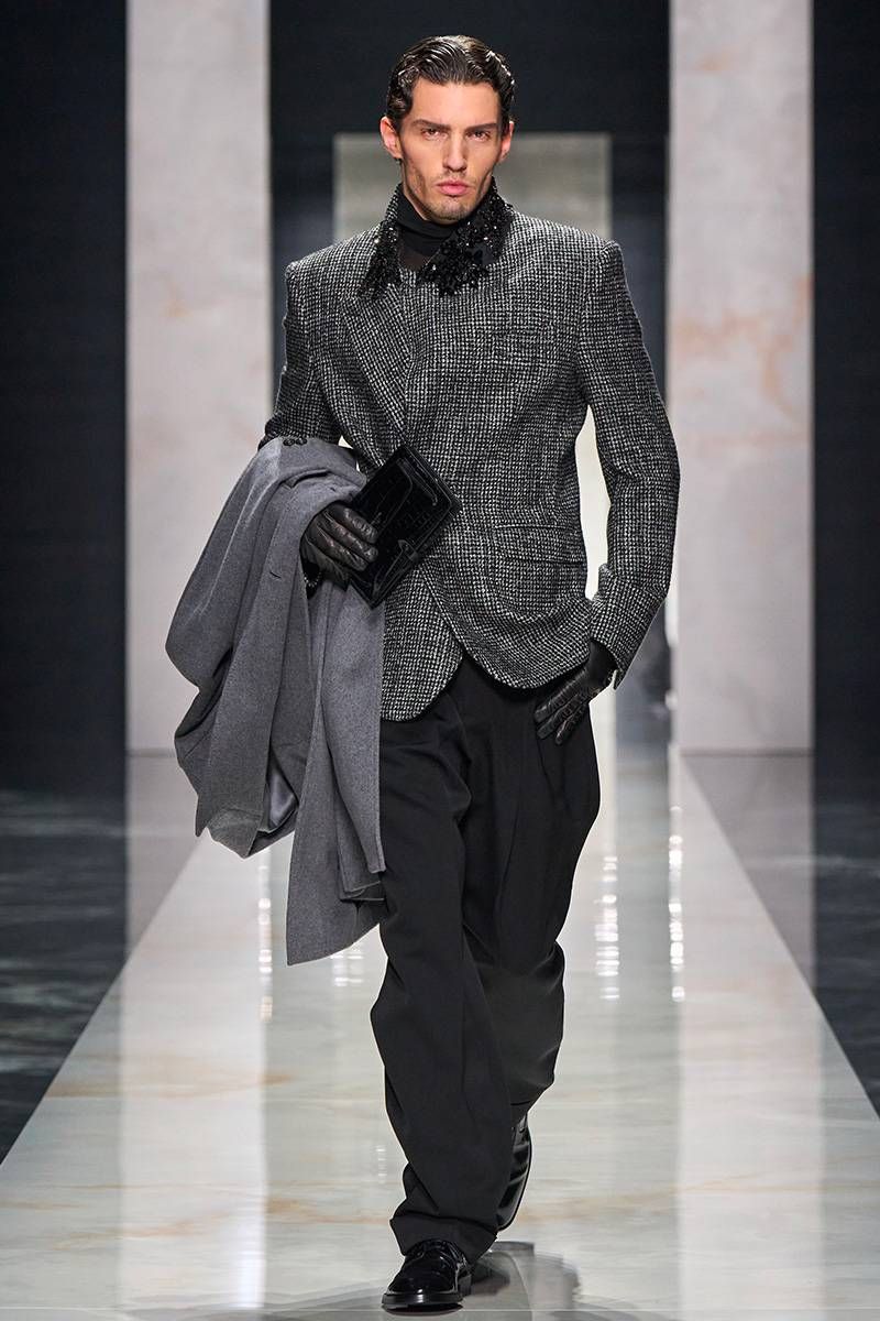 Dolce & Gabbana menswear look with a textured tailored jacket, black trousers, leather gloves, statement collar detailing and a structured clutch 